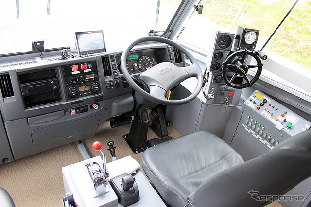 コーワテック製の水陸両用バス。運転席左にスロットルレバー、右に操舵用ステアリングがある。