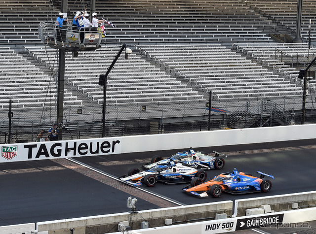 8月の無観客開催となったインディ500、#30 佐藤琢磨(中央)がイエローコーション下でのトップチェッカーを受ける。