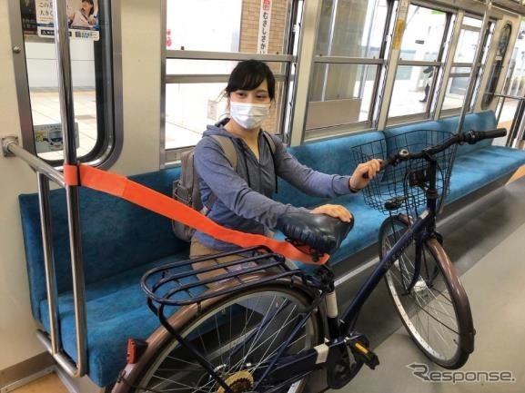 車内には固定具がないため、このように固定ベルトを使い、自転車を自分で支える。