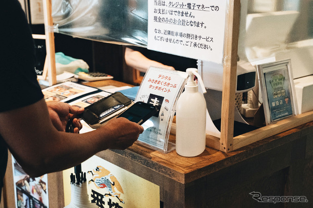 三崎港魚市場食堂で「まんぷく券」をかざす