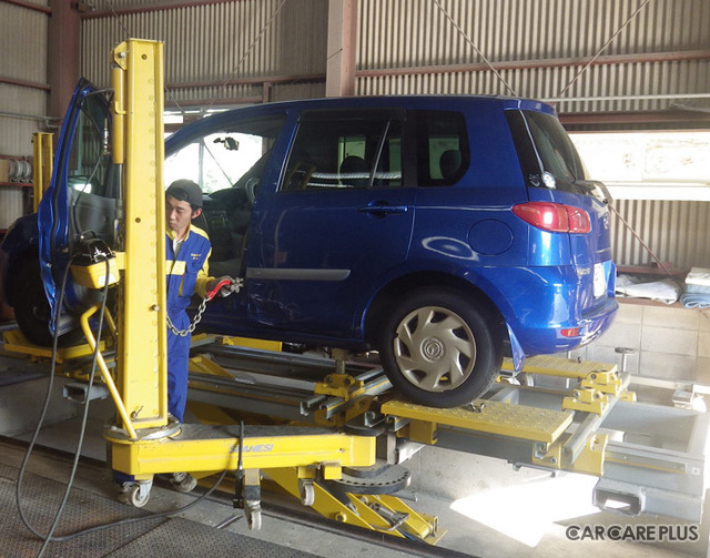 ミリ単位で車体のゆがみを修正できる「ジグ式フレーム修正機」で作業を行っているところ