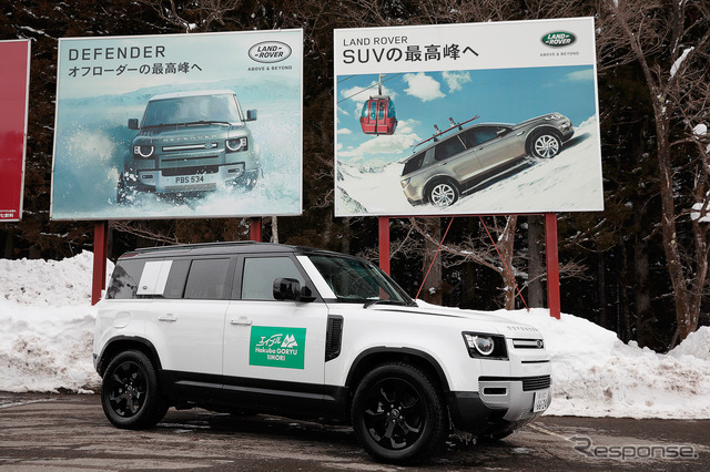 駐車場にはディフェンダーとディスカバリーの広告看板