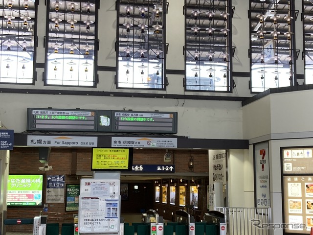 終日運休を伝える小樽駅の改札口。その上を除雪機械が通過していく。2022年2月22日、函館本線小樽駅。
