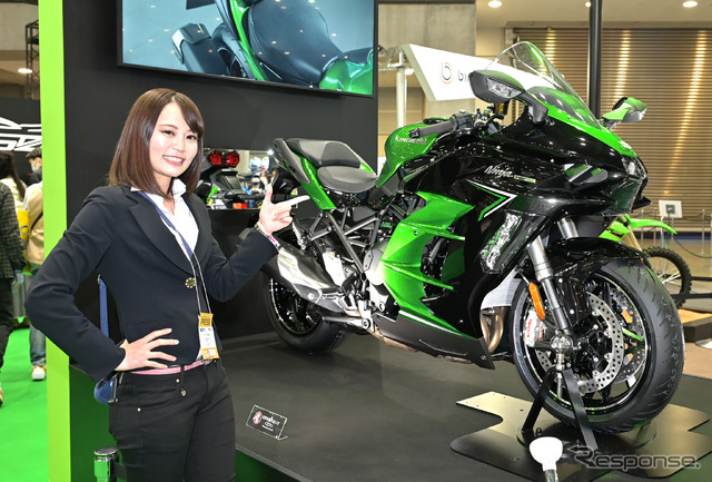 丸山浩氏とともにカワサキブースを取材する小鳥遊レイラさん(ことりちゃん)