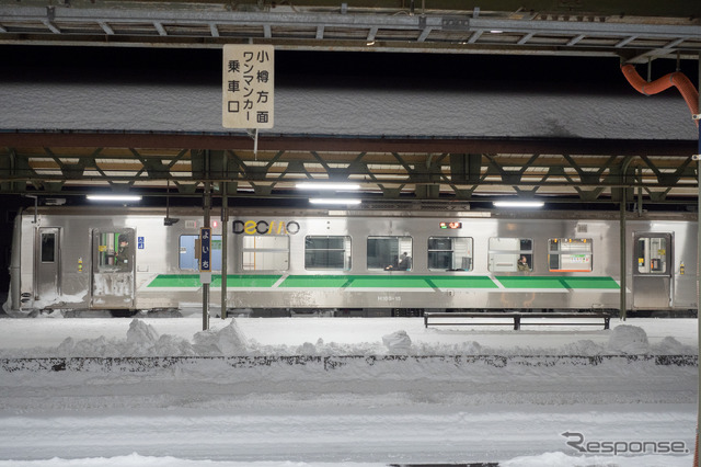 夜の余市駅で発車を待つ小樽行き普通列車。余市～小樽間は輸送密度が2000人/日を超えるものの、深夜の下り列車は1両でも閑散としている。2022年1月2日。