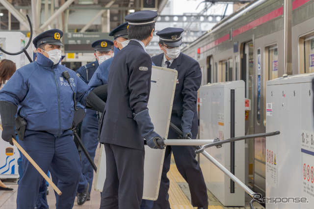 飛田給駅で緊急停車した電車に、警察官と駅員がさすまたや警棒、防護シールドを持って乗り込む。