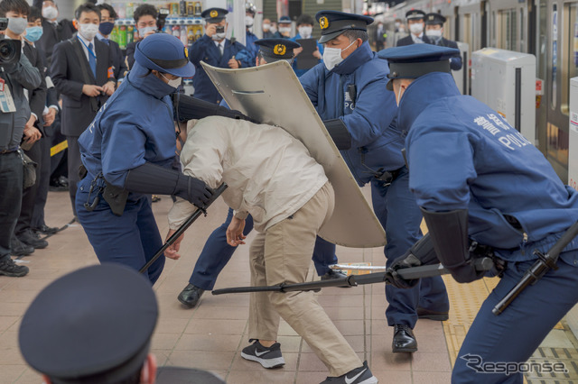 犯人の体勢が崩れたところで一気に数名の警察官が抑えにかかる。