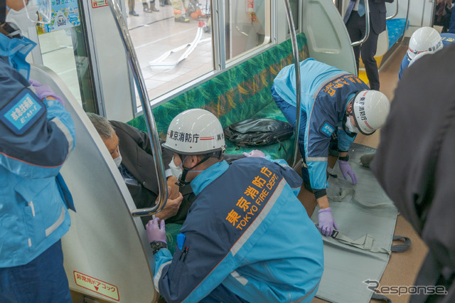 ホームドアが邪魔になり、折りたたみ式のストレッチャーは電車内に持ち込めないため、救護担架が用意された。