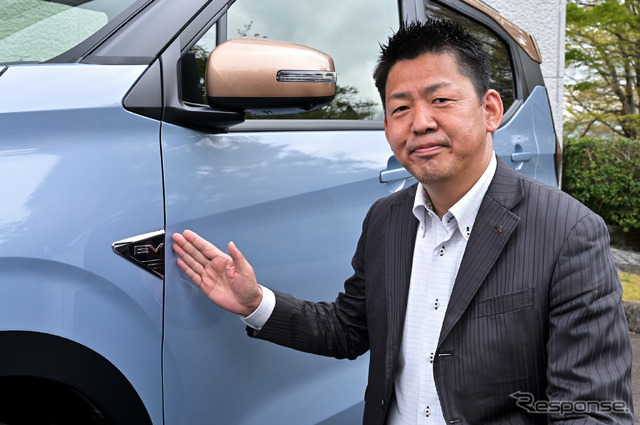 三菱自動車 商品企画本部チーフ・プロダクト・スペシャリストの藤井康輔氏とeKクロスEVの「EVエンブレム」