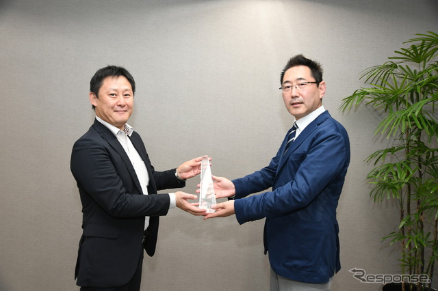 三浦選考委員長(右)からトロフィーを受け取る大矢主査