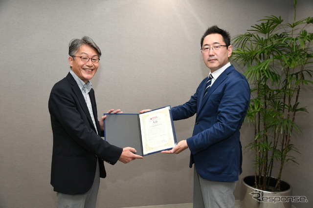 三浦選考委員長(右)から賞状を受け取る菅野主幹