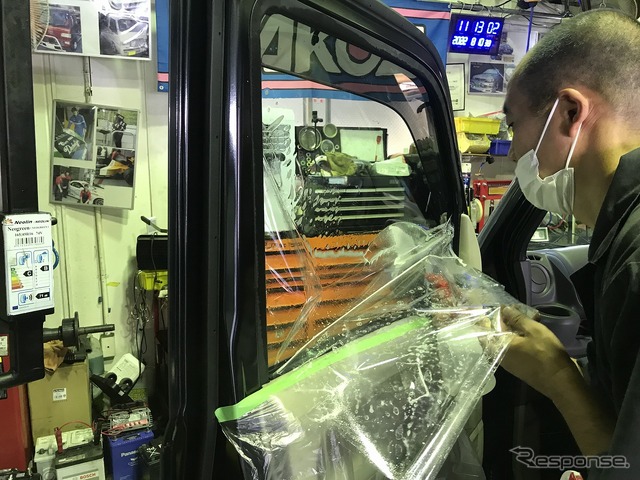 試作車に特許申請フィルム「ahead-TSM90C」を貼る様子