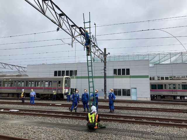 京王電鉄・総合事故復旧訓練:架線の復旧。不測の通電に備えて架線をアースしておく。