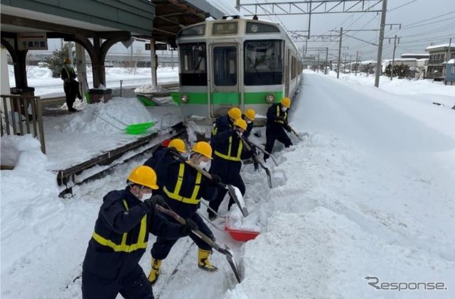 2月6日来の大雪で千歳線平和駅(札幌市厚別区)で立ち往生した721系普通列車の前で懸命に作業を行なう除雪作業員。