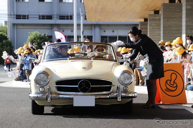 JALのCAからスタンプが押されたシートを受け取るメルセデスベンツ 190SL