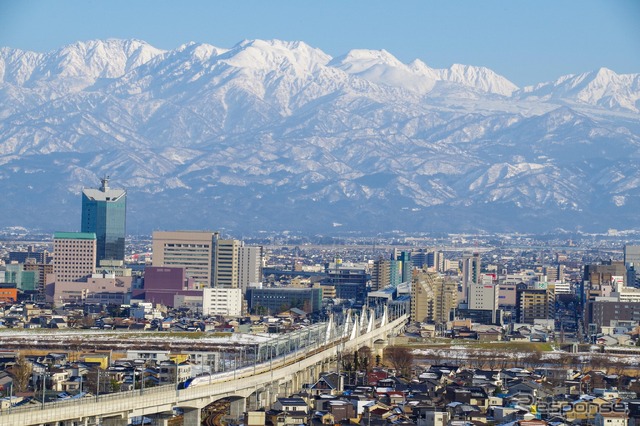 雪の立山連峰をバックに走る北陸新幹線。