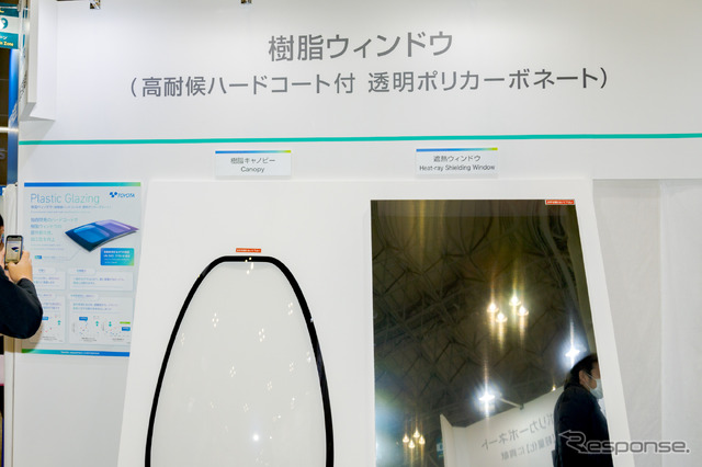 高耐候ハードコートが施された樹脂ウィンドウ。ポリカーボネート製で、コーティングしたあとで曲面加工などが可能という特性もある（高機能素材Week 2022）