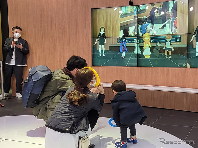 銀座の子供たちの様子を見て驚くメタバース民たちを見ている親子。