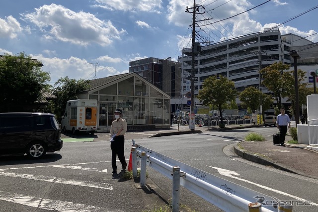 引込線跡。撮影者の左後方が所沢駅で、写真手前のガードレール左側が線路敷地。ガラス面の建物は廃線後にできたと思われ、線路は右にカーブしながら奥の工場に繋がっていた(9月18日)