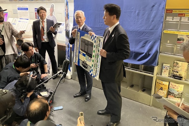 パネルを持つ人物手前が西武の小川車両部長、奥が小田急エンジニアリングの岩﨑社長(崎はたつさき)
