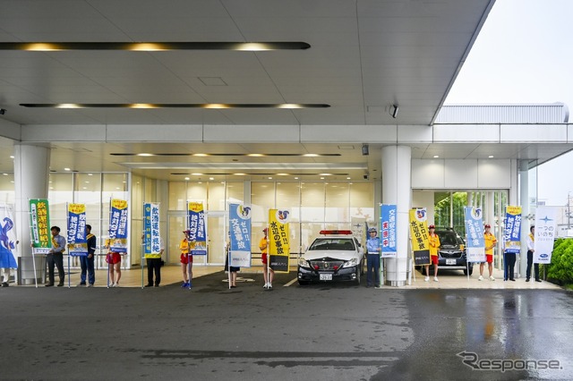 2024年交通安全旗持ち。雨天のため店舗屋根下で開催した