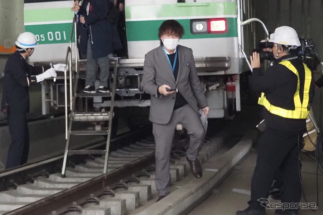 東京メトロ「異常時総合想定訓練」：車内の乗客の避難。スマホのライトで足元を照らすよう案内
