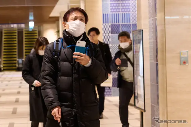 歩行支援スマートフォンアプリを使い、視覚障がい者が日本橋の街中を歩く様子