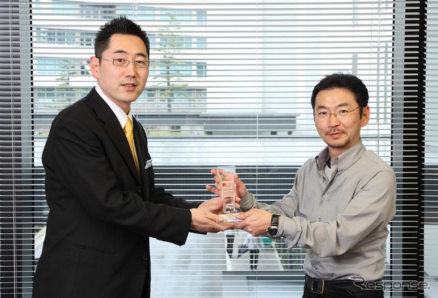 新型プリウスのチーフエンジニア大塚明彦に、レスポンス三浦和也編集長からトロフィーが贈呈された