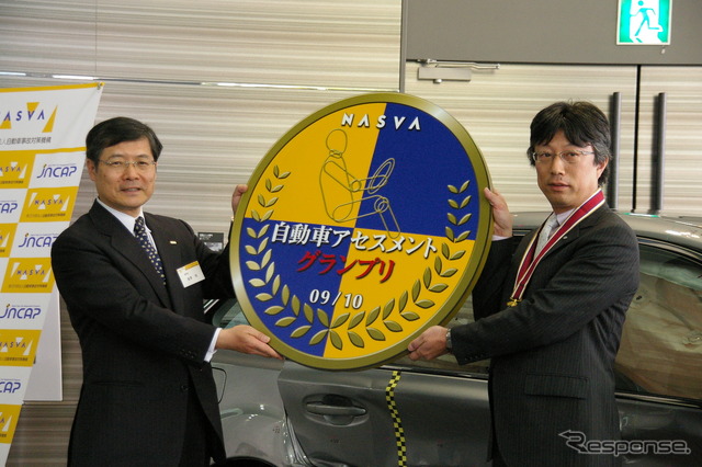 自動車事故対策機構の金澤悟理事長からスバル熊谷氏にメダル、トロフィーが贈呈された