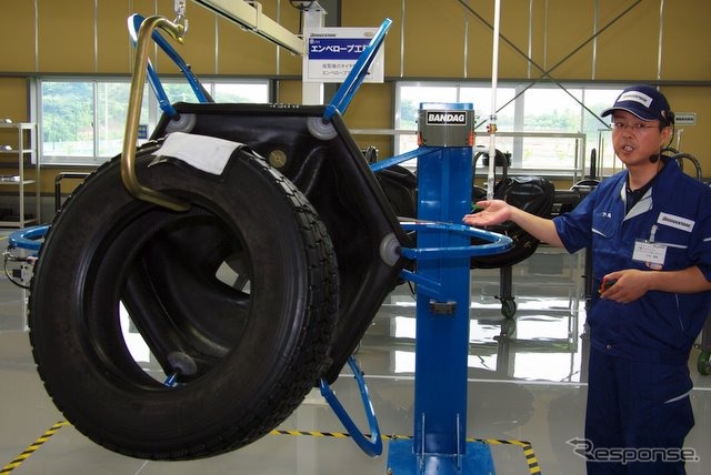 トレッドゴムを貼り込んだタイヤを袋状の覆いで包み込み、加硫工程へ移す