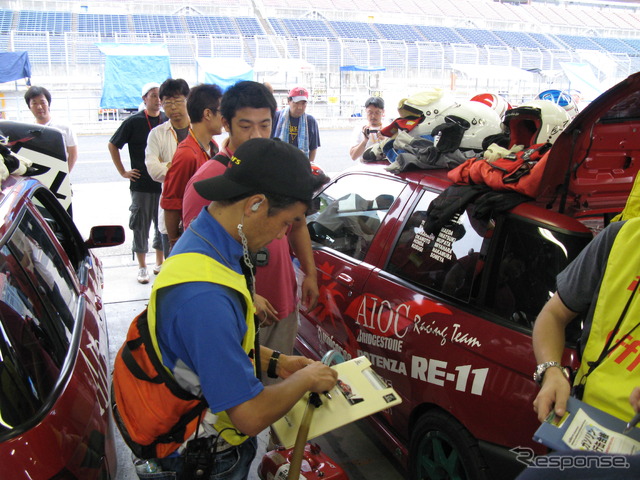 大会当日、朝の車検風景。全ドライバーの装備品から、燃料補給用の携行タンクやフューエルコックまでチェックを受ける