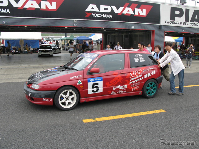 ローリングスタートに備えてピットからホームストレート上のダミーグリッドまで手押しでレースカーを運ぶ。103台ものエントリーがあると最高尾車両はピットロードエントリーの先まで並ぶ事になる
