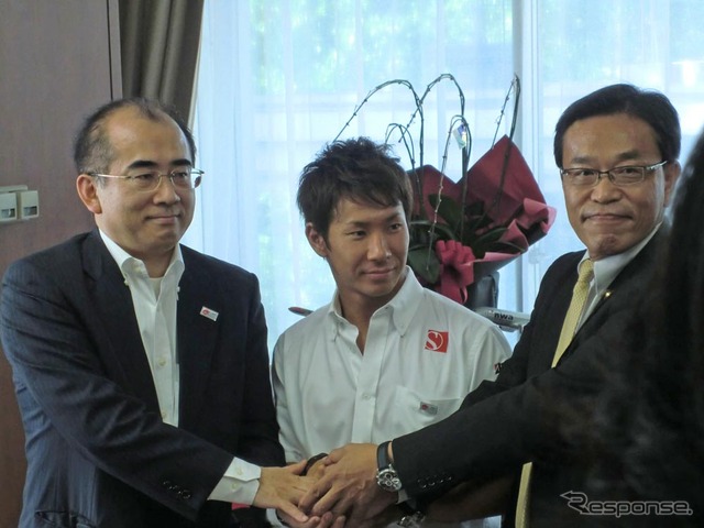 溝畑宏観光庁長官（左）らと握手する小林可夢偉（中央）