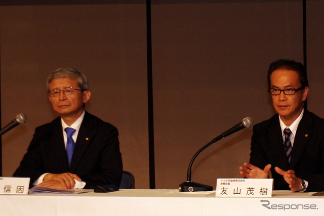 質疑応答で記者団の質問に答える友山常務