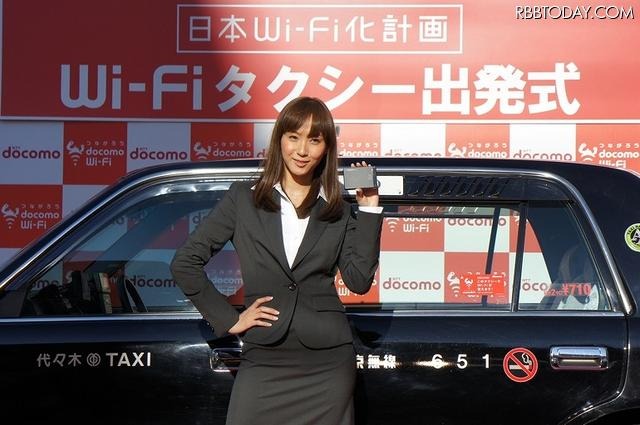 Wi-Fi搭載タクシーを前に、モバイルWi-Fiルータを手にする藤本美貴 Wi-Fi搭載タクシーを前に、モバイルWi-Fiルータを手にする藤本美貴