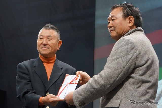 稲田大二郎実行委員長から特別賞を贈られるRE雨宮の雨宮勇美代表