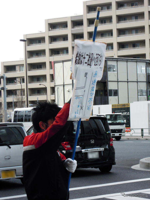 都内でもガソリン需要が高まり、迂回を案内する従業員(2011年3月17日)