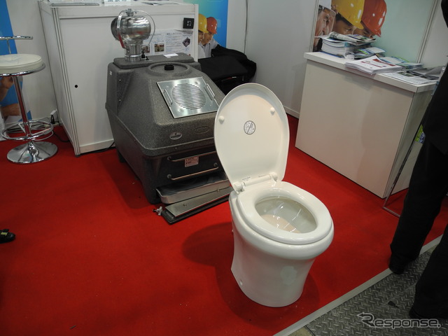 加サンコール・インダストリーズ社のバイオトイレ「エンバイロレット」。後ろにある装置で排泄物を分解して堆肥にする（「スマートエネルギーWeek2013」）