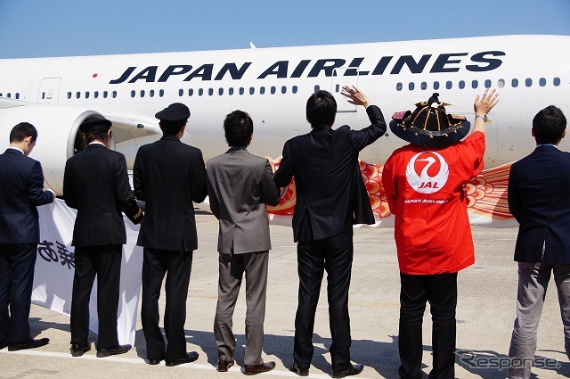 動き出す機体に手を振るスタッフ。