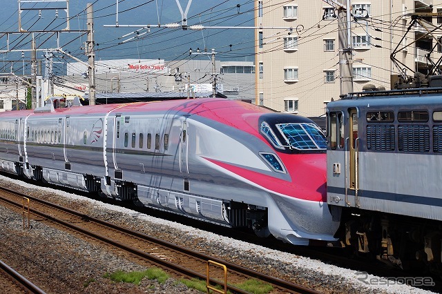 新幹線車両が機関車に牽引され、在来線を走る。