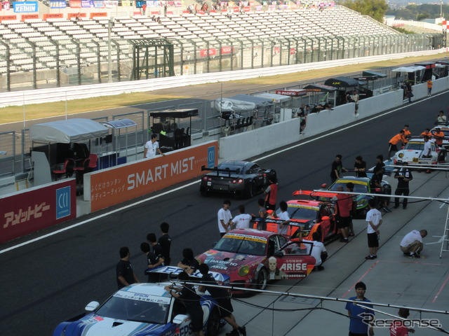 予選前日、現行車両の車検待ち渋滞の横を、14年型GT-Rが通過する。