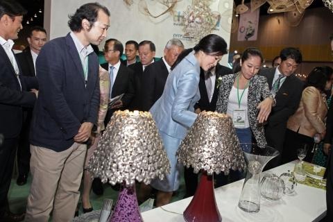有田焼窯元「真右ェ門」の馬場久和氏（左端）と、有田焼とタイ産スズのコラボ作品のシェードランプを視察するインラック首相
