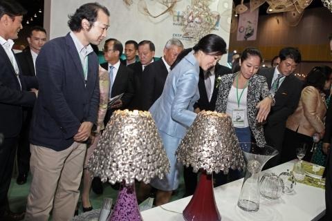 有田焼窯元「真右ェ門」の馬場久和氏(左端)と、有田焼とタイ産スズのコラボ作品のシェードランプを視察するインラック首相