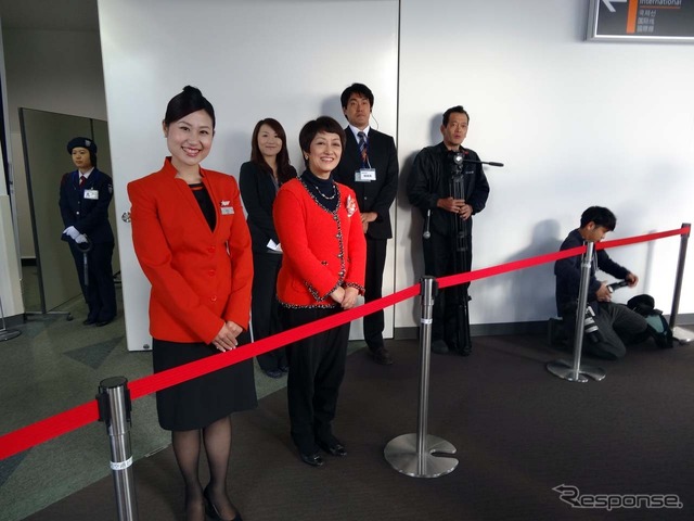 高松空港でボーディングブリッジを渡るとジェットスタージャパンの鈴木みゆき社長(手前列左から2番目)らスタッフがお出迎え