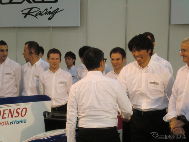 ダカールラリーで市販車部門優勝した三橋が豊田社長（背中）と握手。