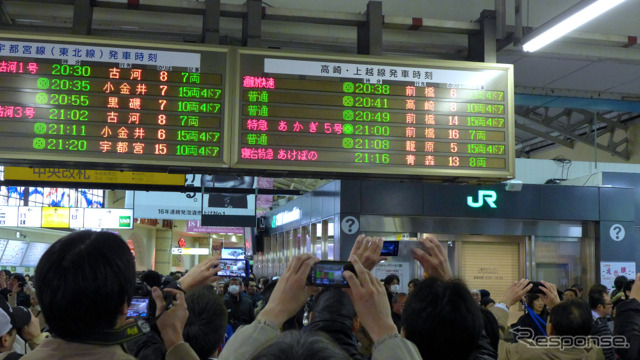 発車案内表示板の『あけぼの』の表示を撮影する人々