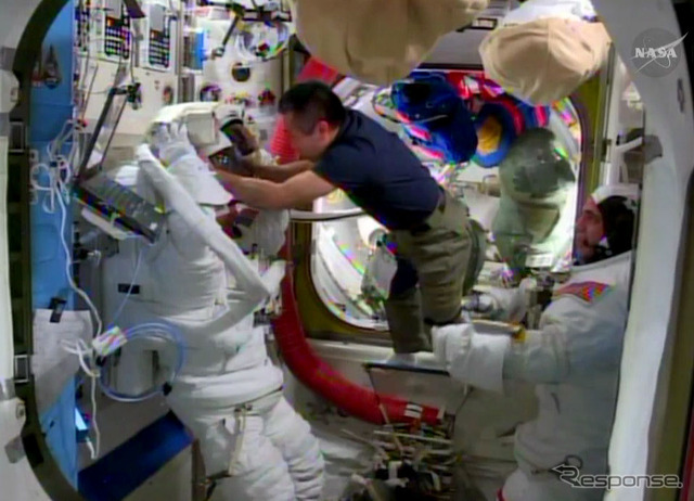 スティーブン・スワンソン宇宙飛行士(左)のヘルメットのフィットチェックを手伝う若田宇宙飛行士(4月17日撮影)(出典:JAXA/NASA)