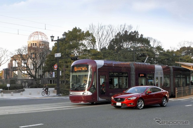 広島電鉄などは路面電車～自動車間通信による安全支援システムのデモンストレーション（2013年10月）で応募した。写真は広島電鉄1000形とマツダ・アテンザASV-5。