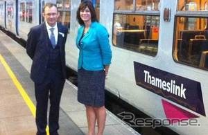 来夏には英国最大の列車運行会社となる予定の、ロンドン近郊の路線網を運行する「ゴヴィア・テムズリンク・レールウェイ」が運行を開始した。写真はロゴが入った列車と同社CEO（左）、ペリー鉄道相