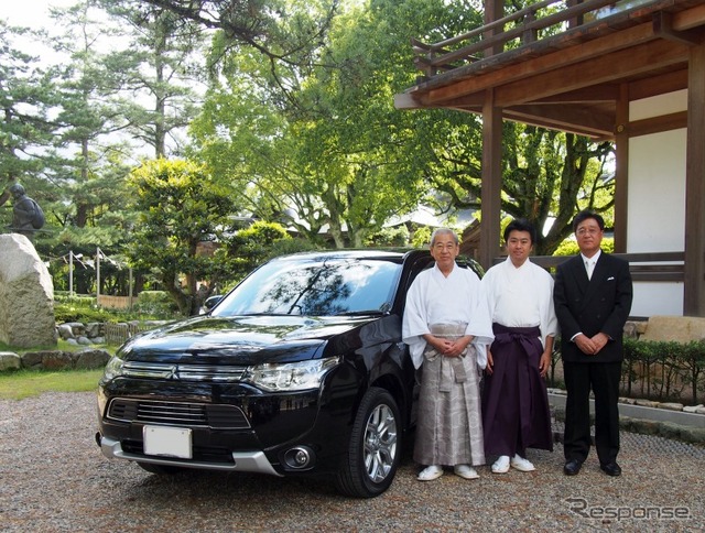 奉納される アウトランダーPHEV を前に記念撮影する関係者